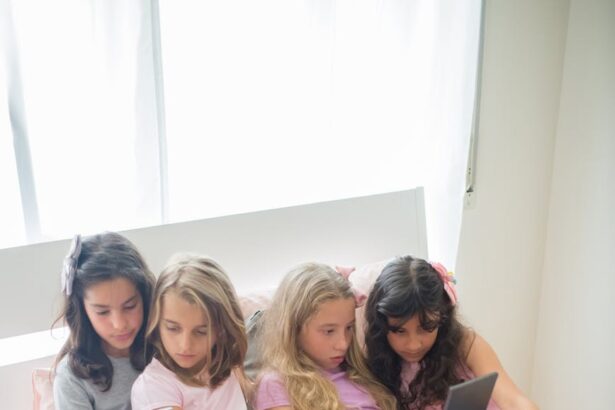 girls sitting on bed using mobile phone